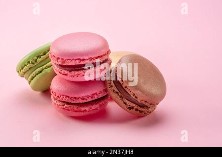 Macaron francesi colorati isolati su sfondo rosa. Foto Stock