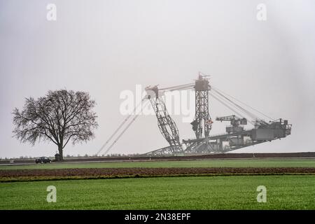 Escavatori della miniera di lignite di opencast Garzweiler II, nell'ex villaggio demolito di Lützerath, sulla strada di campagna L12, nella nebbia, NRW, Germania, Foto Stock