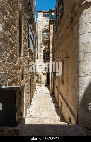 Betlemme, Cisgiordania, Palestina - 21 luglio 2022: Vicolo stretto nell'ombra con le vecchie mura di pietra Foto Stock