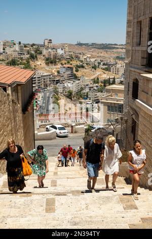 Betlemme, Cisgiordania, Palestina - 21 luglio 2022: Vari turisti camminano sulle scale di una stretta Via Antica presso la Chiesa della Natività Foto Stock