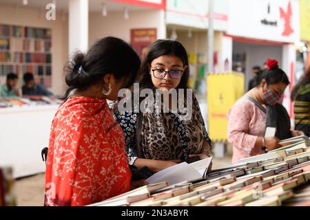 Dhaka, Bangladesh. 07th Feb, 2023. I visitatori leggono libri alla fiera nazionale del libro di nome Ekushey Boi Mela a Dhaka. Ogni anno, la 'Bangla Academy' organizza la fiera nazionale del libro nella zona dell'Università di Dhaka. Questa fiera del libro è la più grande del Bangladesh e si svolge per tutto il mese di febbraio. (Foto di Piyas Biswas/SOPA Images/Sipa USA) Credit: Sipa USA/Alamy Live News Foto Stock