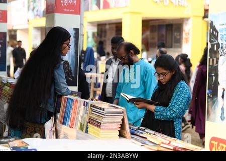 Dhaka, Bangladesh. 07th Feb, 2023. I visitatori leggono libri alla fiera nazionale del libro di nome Ekushey Boi Mela a Dhaka. Ogni anno, la 'Bangla Academy' organizza la fiera nazionale del libro nella zona dell'Università di Dhaka. Questa fiera del libro è la più grande del Bangladesh e si svolge per tutto il mese di febbraio. (Foto di Piyas Biswas/SOPA Images/Sipa USA) Credit: Sipa USA/Alamy Live News Foto Stock