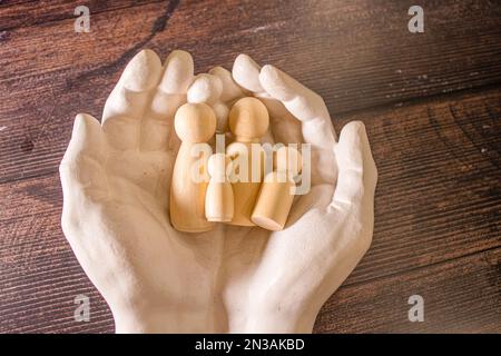 Il giovane ha usato entrambe le sue mani per proteggere dai blocchi di legno cadenti.,il concetto di cura, protezione, protezione dei membri della famiglia per essere saf Foto Stock