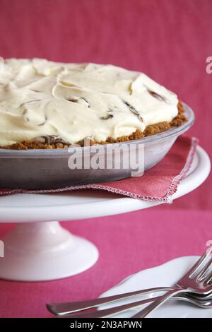 Torta di gelato su un supporto per torta con sfondo rosa Foto Stock