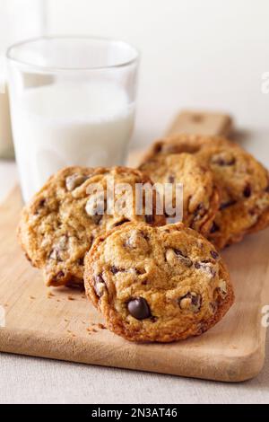 Piatto da portata con biscotti con gocce di cioccolato e un bicchiere di latte Foto Stock