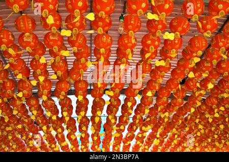 Lanterne di carta rosse e dorate appese al soffitto; Tachaom, Thailandia Foto Stock