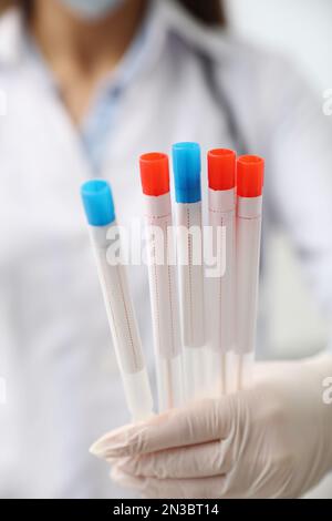 Provette da medico con tamponi di cotone per test del DNA in clinica, primo piano Foto Stock