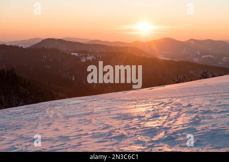 Bellissimo tramonto sulle montagne innevate Foto Stock