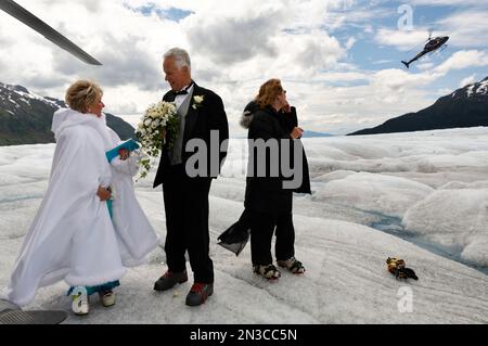 Dopo la cerimonia nuziale sul ghiacciaio Mendenhall, una coppia di sposi aspetta di tornare alla loro nave da crociera in elicottero Foto Stock