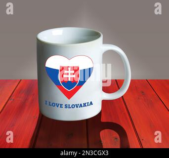 Una tazza bianca vuota su un tavolo di legno con la bandiera e lo stemma della Slovacchia a forma di cuore e l'iscrizione Io amo la Slovacchia. Collage. Foto Stock