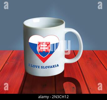 Una tazza bianca vuota su un tavolo di legno con la bandiera e lo stemma della Slovacchia a forma di cuore e l'iscrizione Io amo la Slovacchia. Collage. Foto Stock