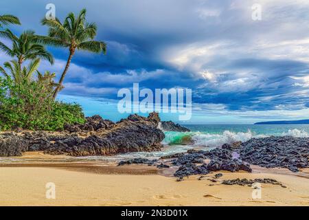 Spiaggia segreta con palme e acque turchesi che si snodano nella sabbia dorata di Makena Cove sull'isola di Maui, Hawaii, USA Foto Stock