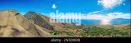 Aerea delle montagne West Maui sopra Launiupoko con la luce del sole che si riflette sull'Oceano Pacifico a Lahaina; Maui, Hawaii, Stati Uniti d'America Foto Stock