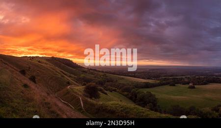 Il sole tramonta sul South Downs National Park inglese, illuminando le piogge come un fuoco; Ditchling, East Sussex, Inghilterra Foto Stock