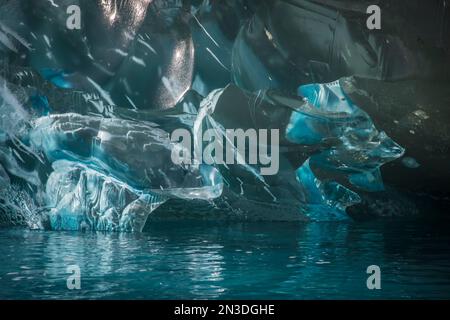 Recinto ghiacciato a Cierva Cove, Antartide. Il colore blu del ghiaccio deriva dalle bolle d'aria che fuoriescono dal ghiaccio per un lungo periodo, aumentando la tana... Foto Stock