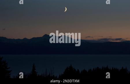 Sagoma dei monti Kenai con l'alba sulla baia di Kachemak al crepuscolo; Homer, Alaska, Stati Uniti d'America Foto Stock