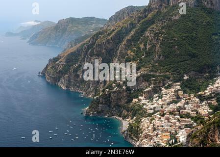 Aereo della cittadina di Positano, con barche ormeggiate lungo la Costiera Amalfitana e vista verso Capri; Positano, Salerno, Italia Foto Stock