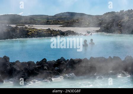 Persone che si godono la Laguna Blu, una sorgente termale artificiale, la laguna vicino a Reykjavik e una popolare attrazione turistica Foto Stock