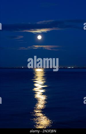 Luna piena e riflesso sull'acqua, vista da Crescent Beach nel Surrey, British Columbia, Canada; Surrey, British Columbia, Canada Foto Stock