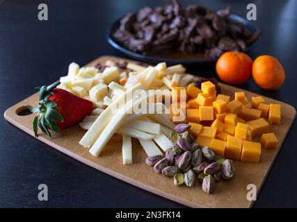 Varietà di cibi sani pronti da servire su una tavola di legno e piatto; studio Foto Stock