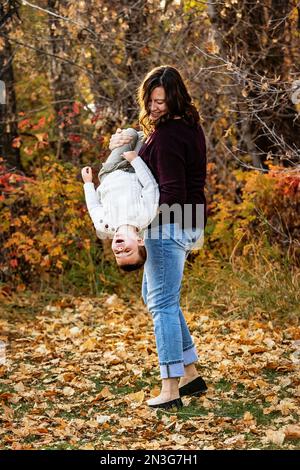 Una madre che trascorre del tempo di qualità e gioca con suo figlio all'aperto in un parco cittadino durante la stagione autunnale; Edmonton, Alberta, Canada Foto Stock