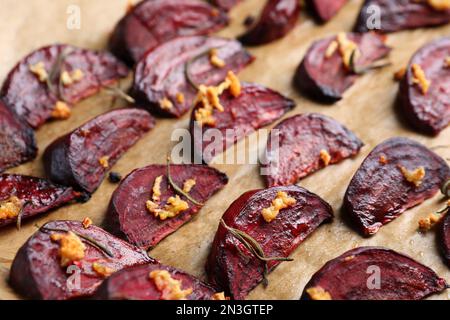 Fettine di barbabietola arrosto con aglio e rosmarino su pergamena, spicchio Foto Stock