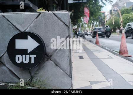 Esci in avanti: Freccia su una strada laterale con sfondo sfocato Foto Stock