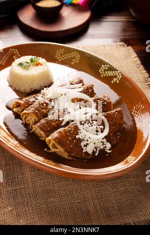 Enmoladas di pollo. Conosciuti anche come mole poblano enchiladas, sono un tipico piatto messicano che è molto popolare in Messico e nel resto del mondo. Foto Stock