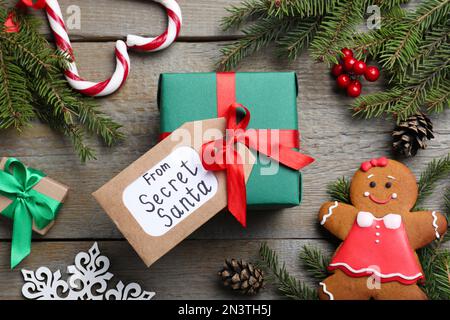 Composizione piatta con regali da Santa segreta su tavola di legno Foto Stock