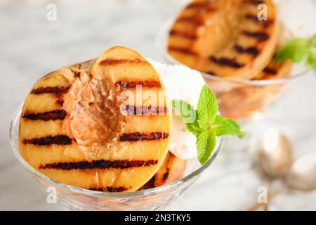 Deliziosa pesca alla griglia con gelato e menta, primo piano Foto Stock