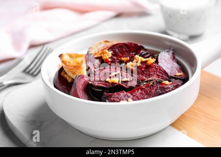 Ciotola con fettine di barbabietole tostate, aglio e rosmarino a bordo, spicchio Foto Stock