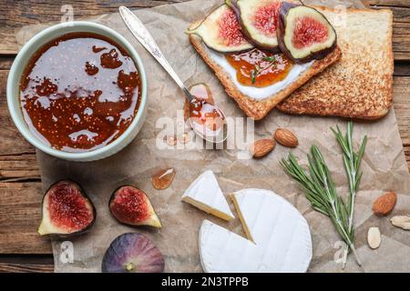 Composizione di posa piatta con deliziosa marmellata di fichi su tavolo di legno Foto Stock