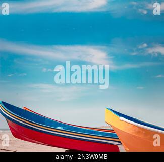 Barche di legno parcheggiate sulla sabbia, colorate barche da pesca parcheggiate vicino all'oceano, closeup di barche bloccate sulla riva dell'oceano con cielo blu e copia Foto Stock