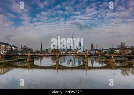 Vista dal Floeserbruecke sul fiume meno, sul ponte Ignatz-Bubis-Bruecke fino allo skyline e ai grattacieli. Bella riflessione dentro Foto Stock