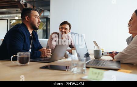 Professionisti del marketing che discutono durante una riunione. Gruppo di persone creative che organizzano una riunione in una sala riunioni. team aziendale che lavora Foto Stock