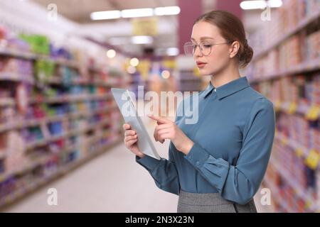 Ispettore con tablet in supermercato. Controllo di qualità Foto Stock