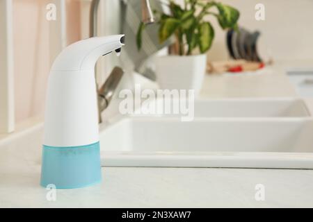 Moderno dispenser automatico di sapone sul piano del bagno. Spazio per il  testo Foto stock - Alamy