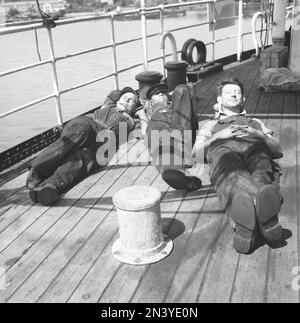 Avere un pisolino negli anni '1940s. Tre marinai stanchi che riposano sul ponte sotto il sole. Fanno parte dell'equipaggio di una nave norvegese, bloccata in Svezia durante la seconda guerra mondiale, senza alcuna possibilità di tornare in Norvegia che a quel tempo fu invasa dalla Germania nazista. Svezia 11 giugno 1940 Kristoffersson Ref 147-13 Foto Stock