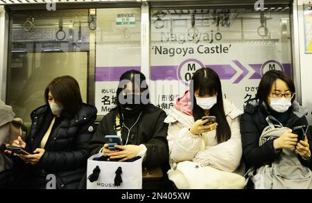 Donne giapponesi che usano i loro smartphone su un treno locale della metropolitana a Nagoya, Giappone. Foto Stock