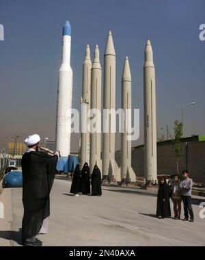Iranian cleric Mohammad Kalbasi takes a photo of his family in front of missiles displayed at an exhibition on the 1980-88 Iran-Iraq war, at a park, northern Tehran, Iran, Thursday, Sept. 25, 2014. Iran begun a week of celebration starting Monday called 'Sacred Defense Week' to mark the 34th anniversary of the outset of its war with Iraq which imposed by the Iraqi dictator Saddam Hussein that left about a million casualties on both sides. (AP Photo/Vahid Salemi)