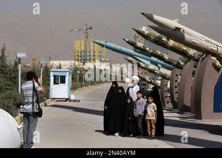 Iranian photographer Arash Khamooshi takes a photograph of cleric Mohammad Kalbasi and his family as they visit an exhibition on the 1980-88 Iran-Iraq war, at a park, northern Tehran, Iran, Thursday, Sept. 25, 2014. Iran begun a week of celebration starting Monday called 'Sacred Defense Week' to mark the 34th anniversary of the outset of its war with Iraq which imposed by the Iraqi dictator Saddam Hussein that left about a million casualties on both sides. (AP Photo/Vahid Salemi)