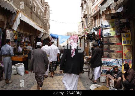 Gli amanti dello shopping passeggiando attraverso gli stretti vicoli vicino a Bab al Yaman, la Città Vecchia, Sanaa, Yemen Foto Stock