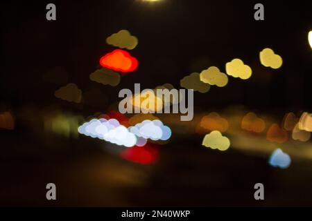 nuvola forma sfondo bokeh sfocato, molti oggetti, colorato rosso giallo arancione blu, bagliore in movimento, luci auto sulla strada sfocata, di notte. concetto backgro Foto Stock