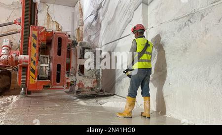 Pale gommate che lavorano su enormi cave di marmo. Foto Stock