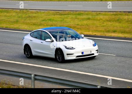 Auto elettrica bianca Tesla modello 3 ad alta velocità in autostrada. Salo, Finlandia. Luglio 9, 2021. Foto Stock