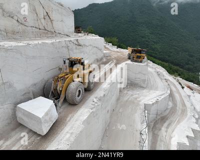 Pale gommate che lavorano su enormi cave di marmo. Foto Stock