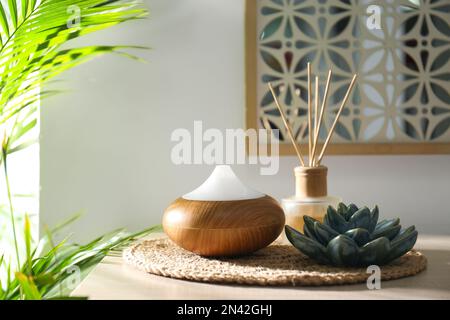 Diffusore di olio aromatico e deodorante d'aria a canna sul tavolo in camera Foto Stock