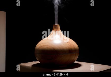 profumo di legno sul tavolo da scrivania con essenza di vapore di oli naturali Foto Stock