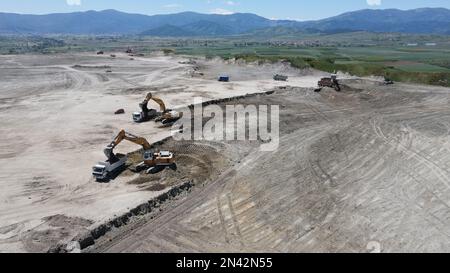 Escavatori in funzione. Caricamento di autocarri in un enorme sito minerario. Foto Stock