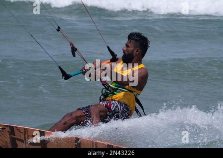 Una pratica kite surf maschile con pelle scura sull'acqua vicino alla spiaggia di Kudawa, Sri Lanka Foto Stock